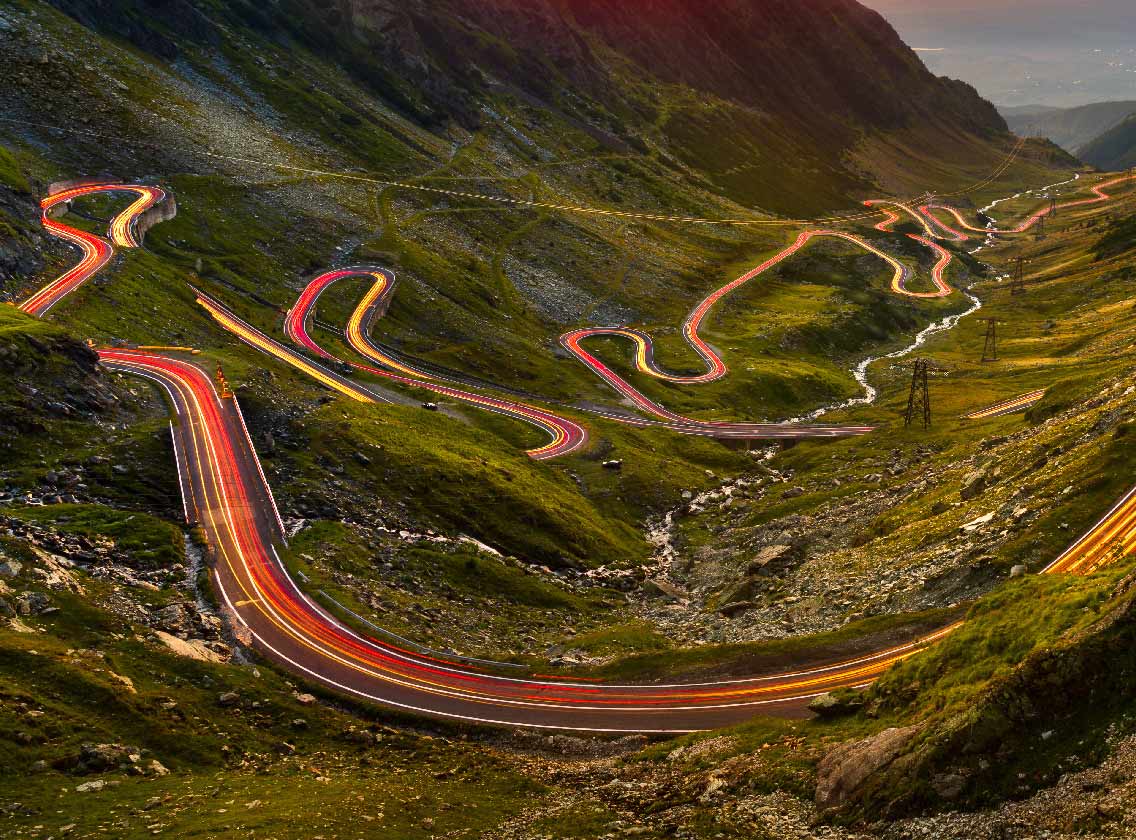 Verkehrsspuren auf der Transfăgărășan in Rumänien bei Sonnenuntergang 