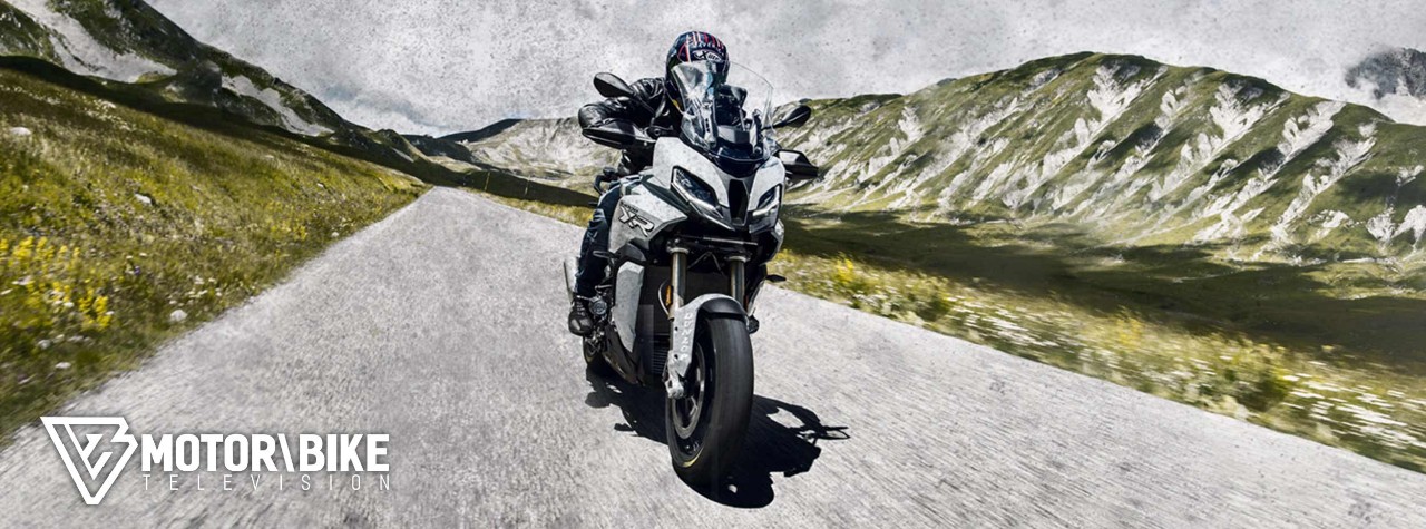 BMW S 1000 XR riding on Dunlop Mutant tyres with mountains in the background