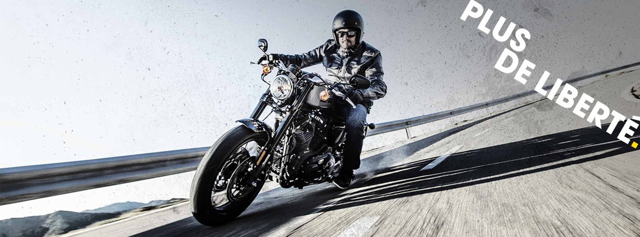 Pilote Harley-Davidson sur route de montagne sur pneus Dunlop