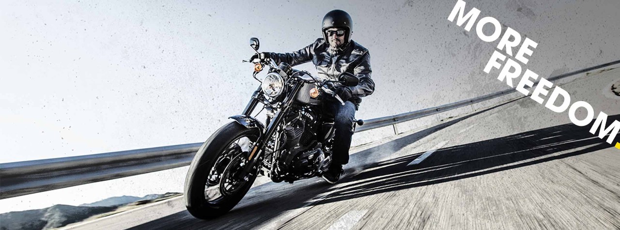 Harley-Davidson-ryttare på bergsväg på Dunlop-däck